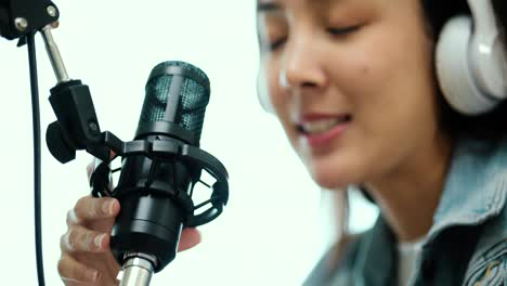 close-up condenser microphone of content creator woman host streaming his a podcast on laptop with headphones interview conversation at home broadcast studio. blogger recording voice over radio.