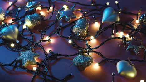 close-up shot of garland with golden lights and christmas toys on color background. christmas concept. home decor. beautiful bokeh