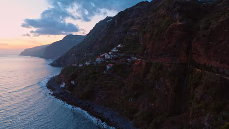 cozy village locating on the slope of the rock. mountainous shore of madeira, portugal at the waterscape of the atlantic ocean. aerial view.