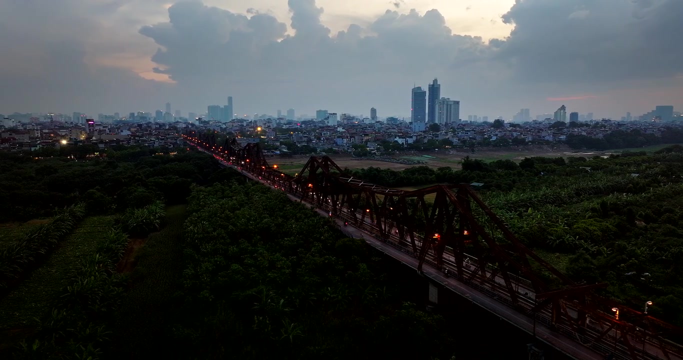 Ponte Long Bien con lo skyline sullo sfondo, paesaggio urbano di Hanoi al tramonto, Vietnam. Vista aerea da drone