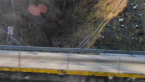 una vista desde un puente de corte de carretera mirando a un barranco boscoso