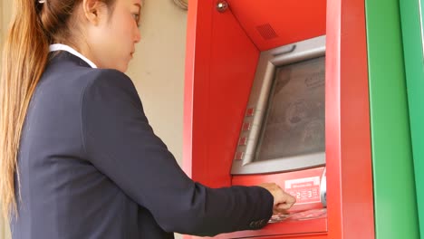 4k of young woman withdrawing money from an atm