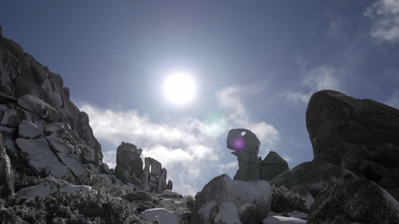 Sunlight over rocky snowy peaks at La Maliciosa, resembling a dinosaur shape