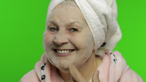 Elderly-grandmother-after-shower.-Old-woman-applying-cosmetic-bubble-face-mask