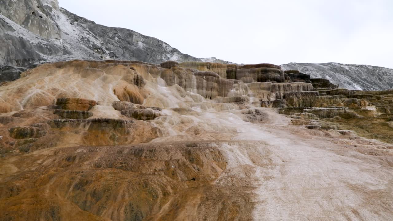 terrazas de piedra caliza travertina en mammoth hot springs con vapor subiendo en el parque nacional de yellowstone, wyoming, ee.uu.