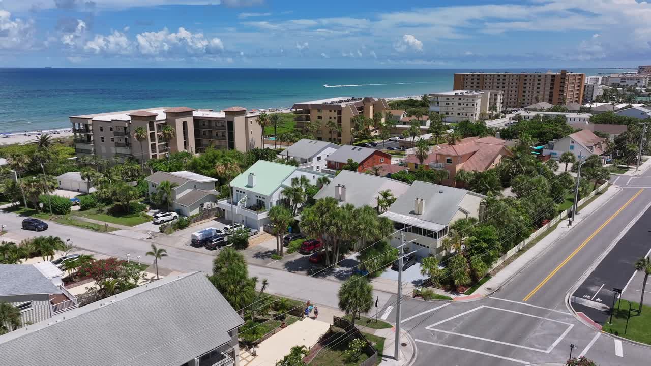 Aerial view of a coastal town with houses, beach, and ocean