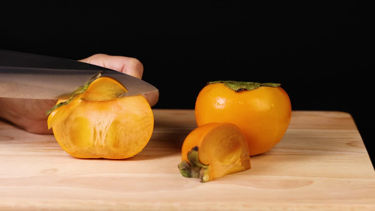 En persimmon skæres i skiver med en kniv