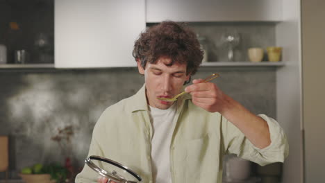 man tastes disappointing food in kitchen