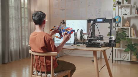 teenager learning 3d printing and creating a robot model at home