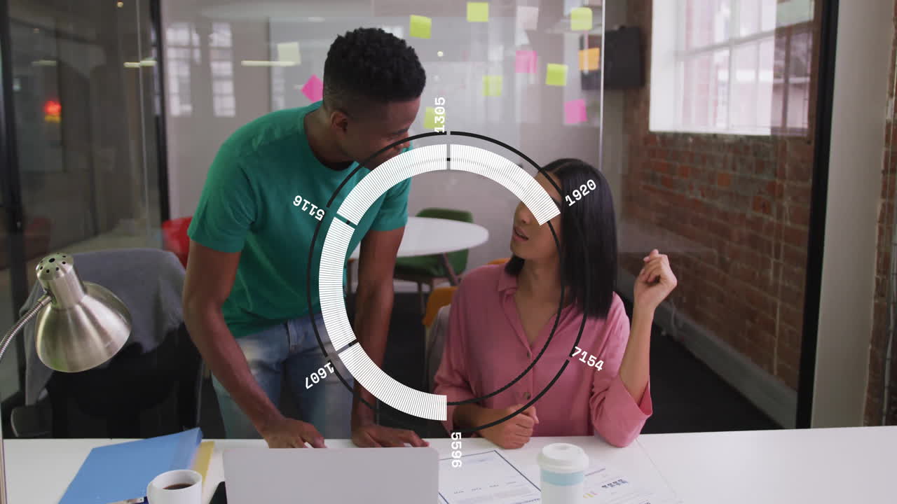 Discussing work, diverse colleagues at office desk with data animation overlay