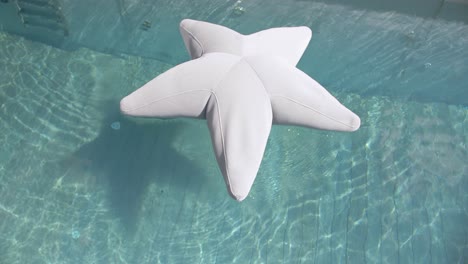 disparo de arriba hacia abajo de una estrella inflable flotando en la superficie de una piscina privada