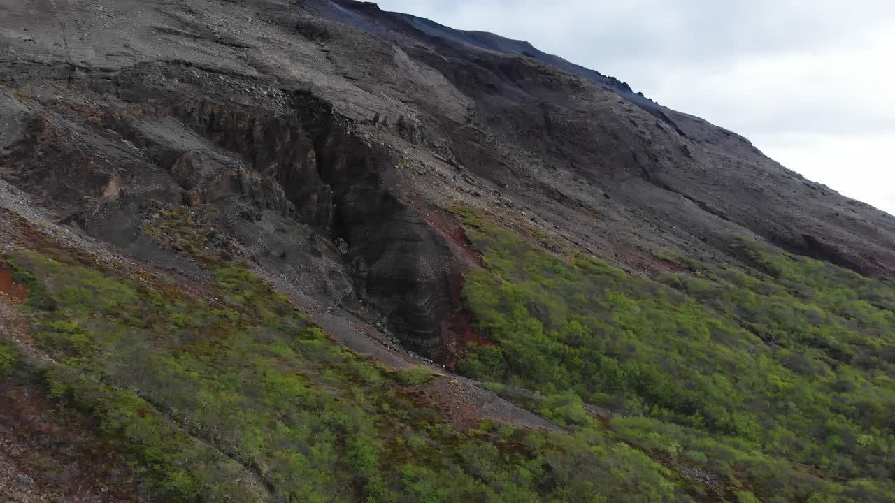 아이슬란드 고지에 위치한 장엄한 산으로 들어가는 동굴 입구를 보여주는 공중 전망