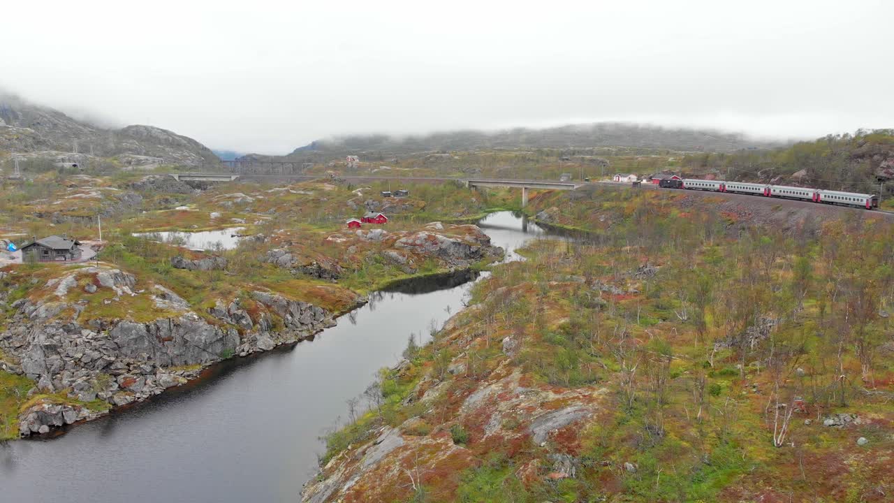 aéreo: tren de pasajeros sueco en el norte de noruega cerca de la estación de søsterbekk junto a un lago