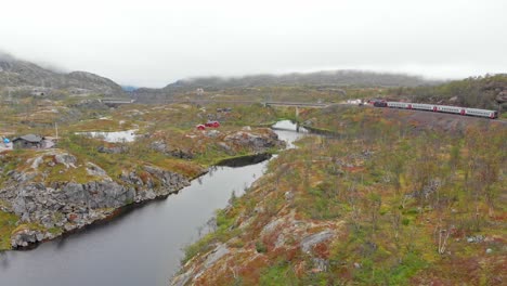 aéreo: tren de pasajeros sueco en el norte de noruega cerca de la estación de søsterbekk junto a un lago