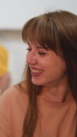 family has dinner together in kitchen. husband entertains wife with funny stories and woman laughs happily covering face with palm on blurred background closeup