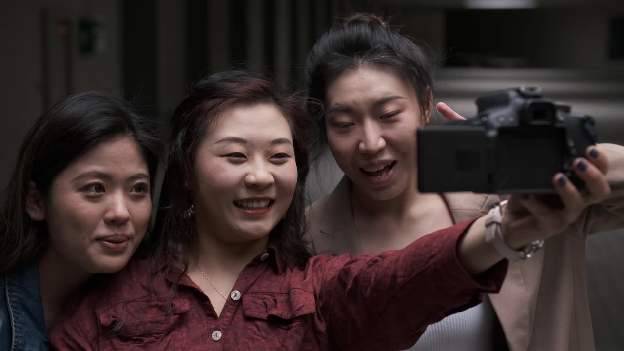 Asian female friends bloggers creating content for social media while making a video with a camera.