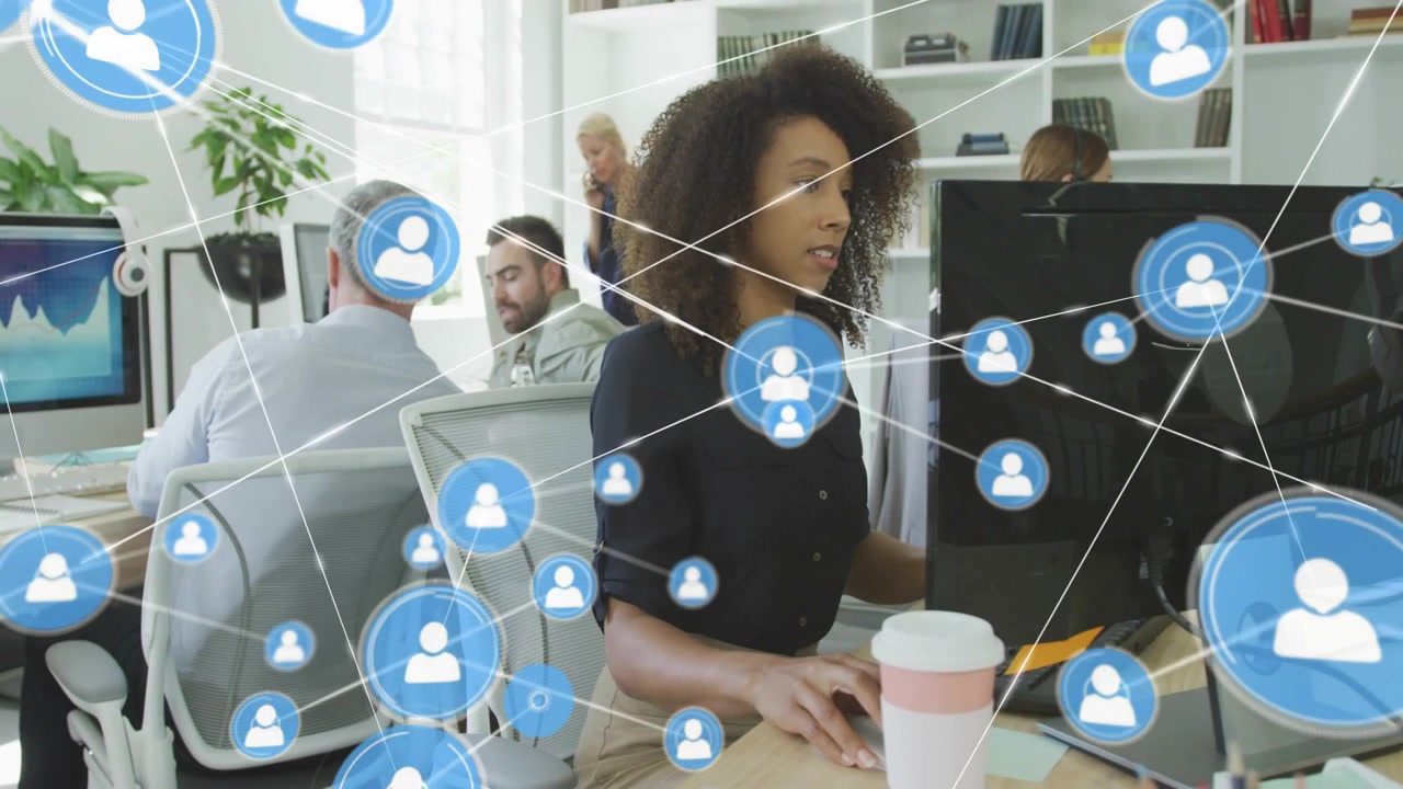Woman working while node appearing by monitor expanding network overlay showing business user links