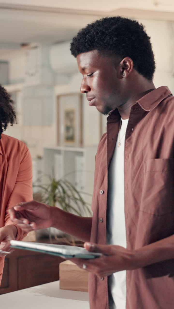 Young Black Man and Woman Collaborating with Digital Tablet in Office