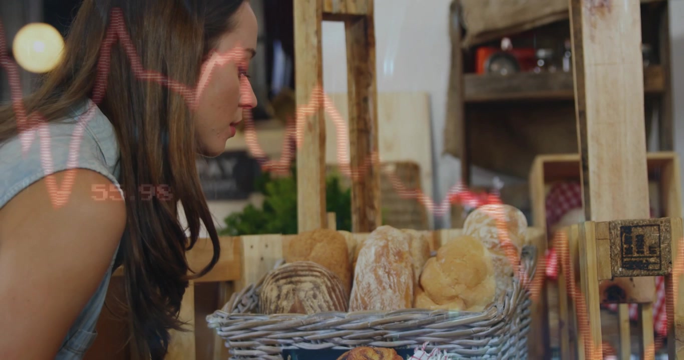 Woman shopper approaching bakery display leaning smelling bread, judging freshness as charts drift