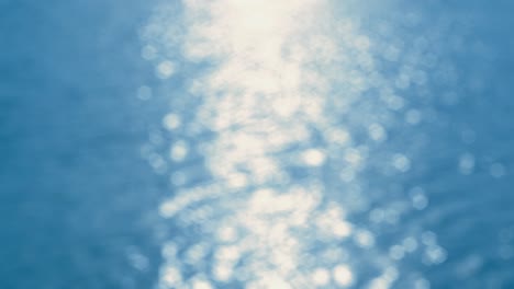 por el agua - el bucle sin costuras de una toma de 4k completamente desfocada de una hermosa superficie de agua ondulada y brillante en un día soleado