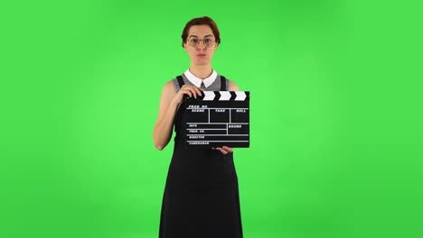 mujer con clapperboard en la pantalla verde