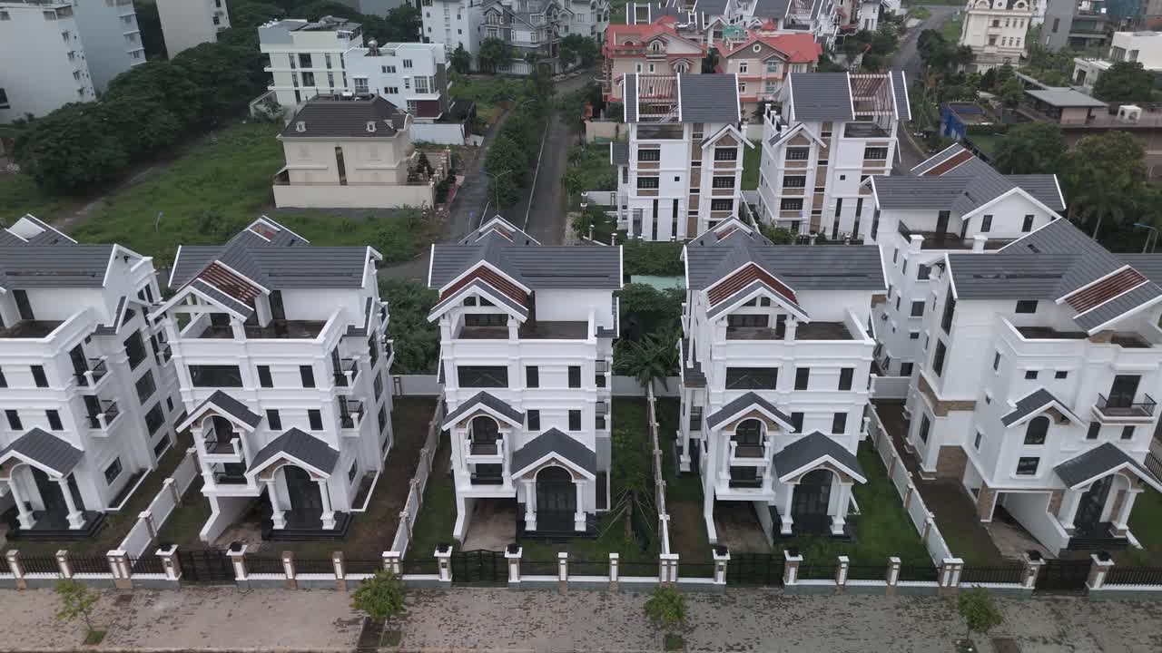 교외 도로를 따라 새로 지어진 동일한 큰 색 다층 빌라 스타일의 집들의 줄