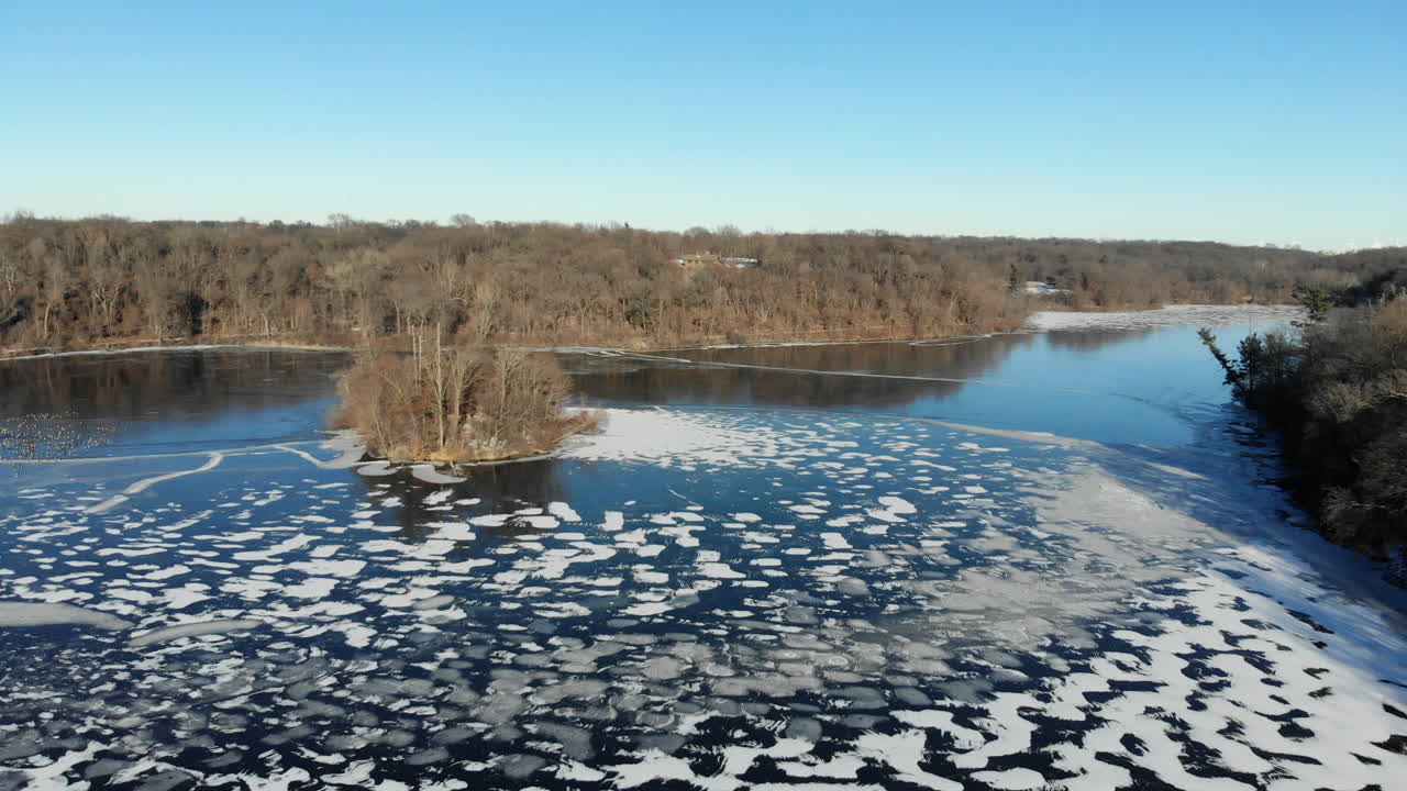 Aerial video over a beautiful half frozen lake in the heart of rural America