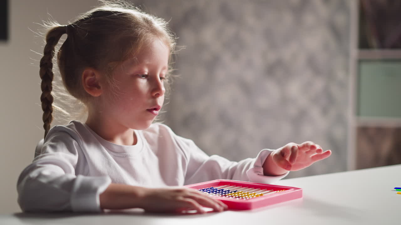 Una bambina impara a contare con l'abaco e parla a lezione.