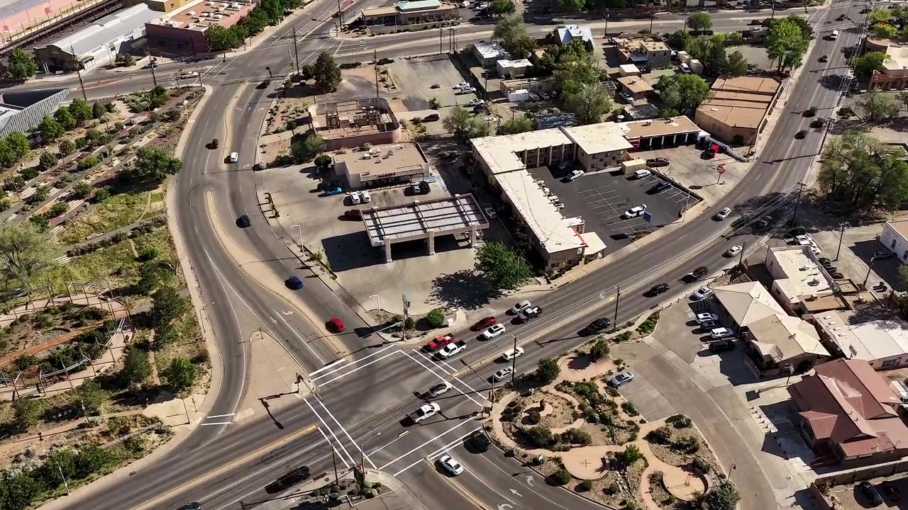 Timelapse statico 4K cattura il traffico intenso dell'ora di punta mattutina che scorre attraverso un incrocio a Santa Fe, Nuovo Messico. Filmato urbano cinematografico rivela veicoli pendolari in rapido movimento su due strade a più corsie