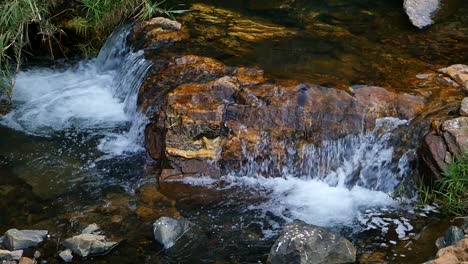 Slow-Motion-shot-Zooming-in-to-water-stream-flowing-over-rocks-in-river-at-the-Walter-Sisulu-National-Botanical-Garden-in-Johannesburg,-South-Africa