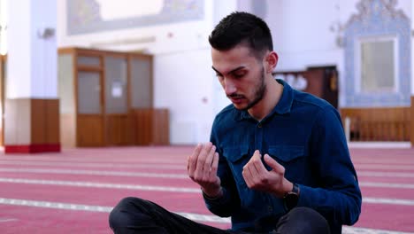 man raising his hands and praying in a mosque 1