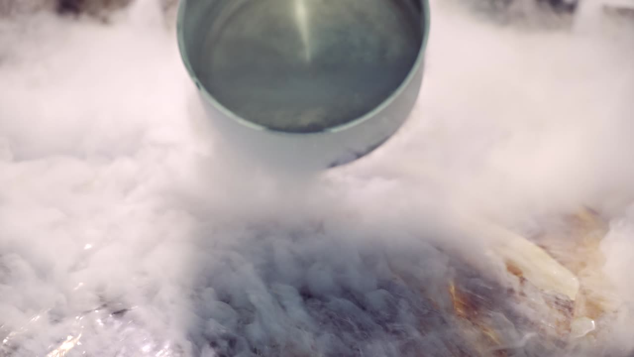 연기의 배경에서 액체 질소로 아이스크림을 준비하는 프레젠테이션.