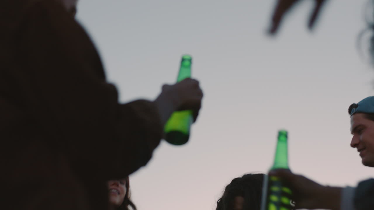 amici felici che ballano che festeggiano sul tetto al tramonto che si godono la festa del fine settimana che si divertono che socializzano che si divertono che bevono alcol
