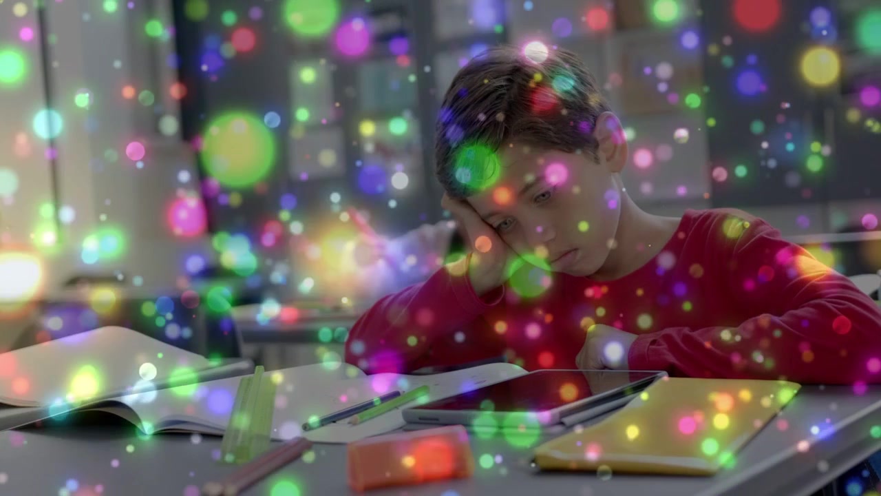 Teacher cueing, male student leaning, glancing at tablet, book, doing classwork with bokeh drifting
