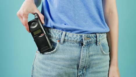주머니에 플립 드폰을 들고 있는 여자