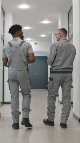 two workers walking in a modern office hallway