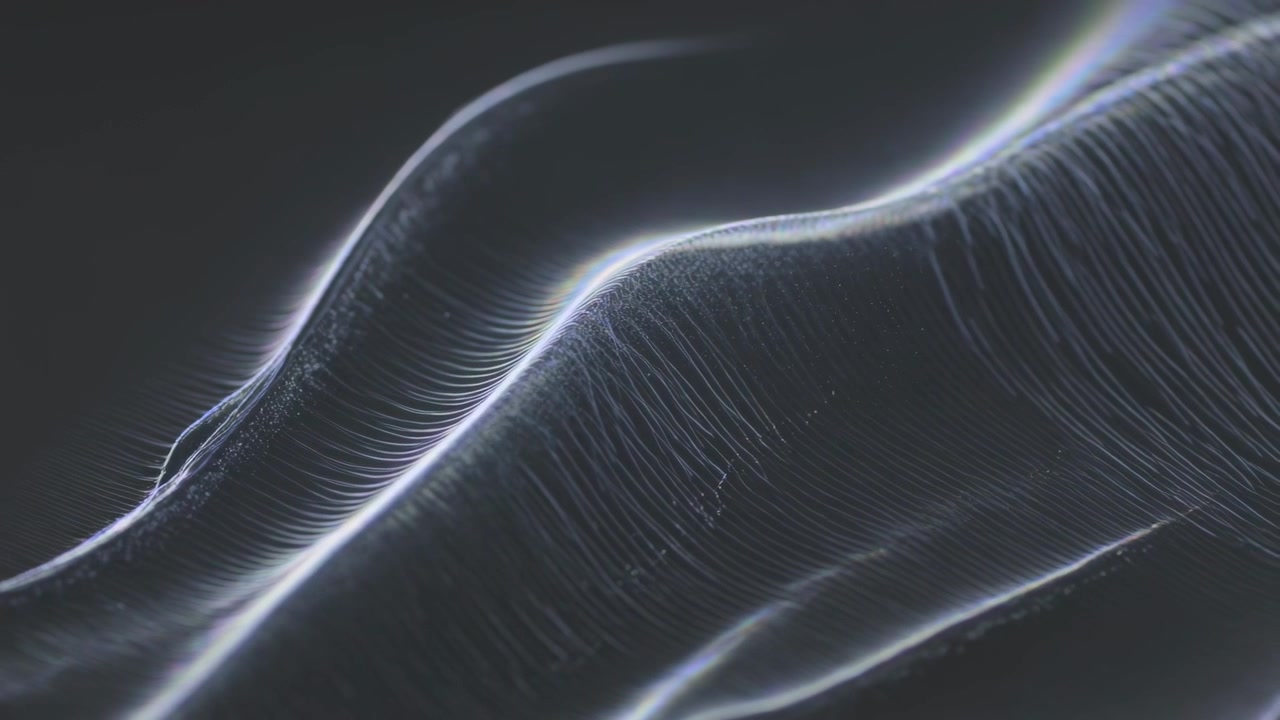 Brightening ridge casting rim light on dark field, luminous ribbons sweeping right with particles
