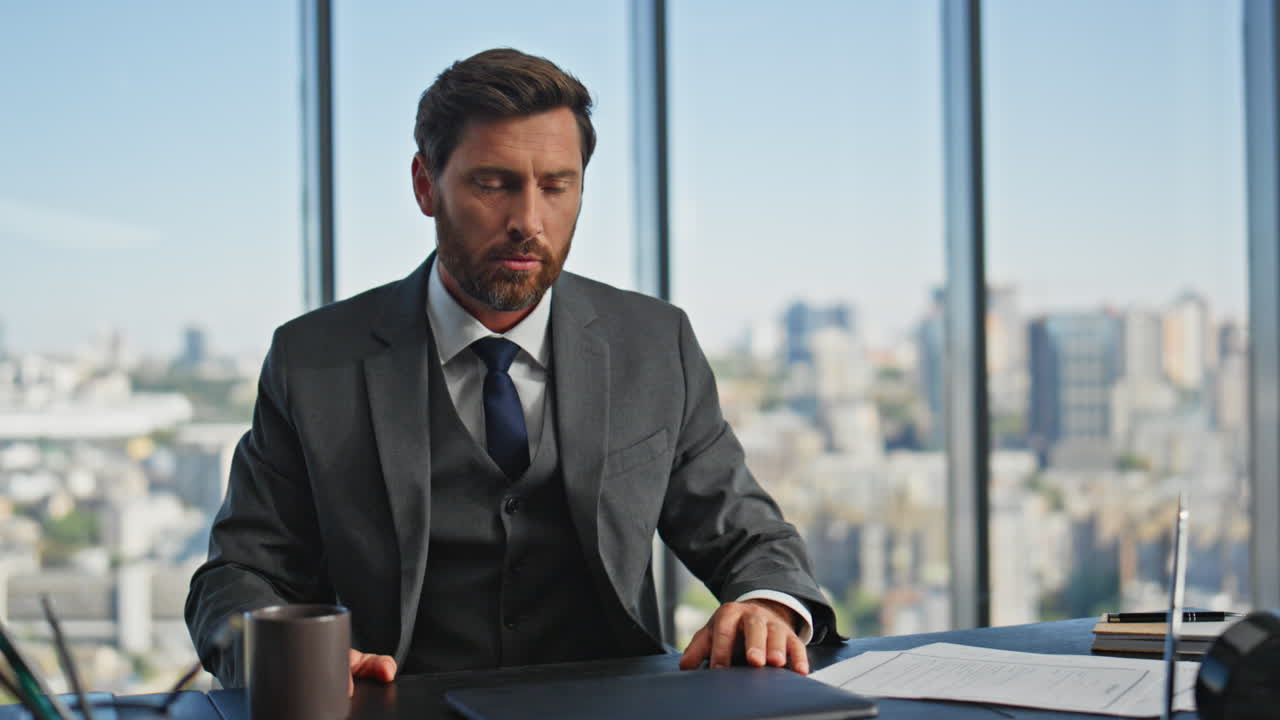 Irritated businessman talking laptop call in panoramic office. Angry man arguing