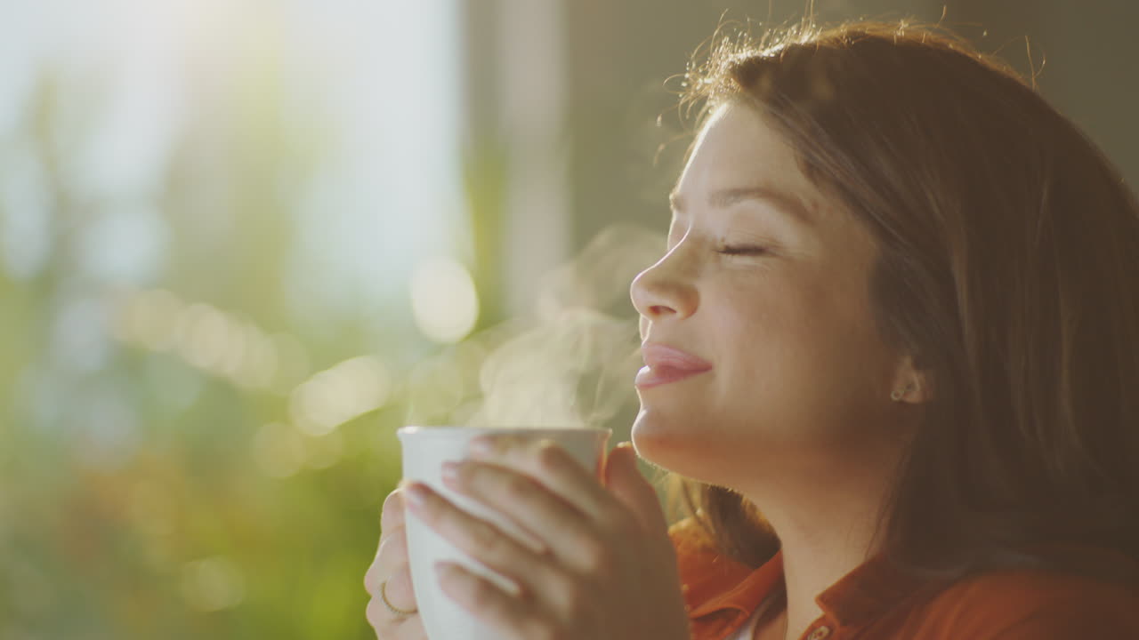 Woman enjoying a cup of coffee by the window