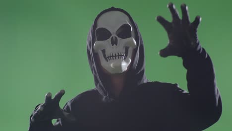 child in a skeleton mask costume on green screen