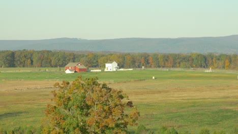 wide shot of the farmland of the battle of gettysburg with a red barn