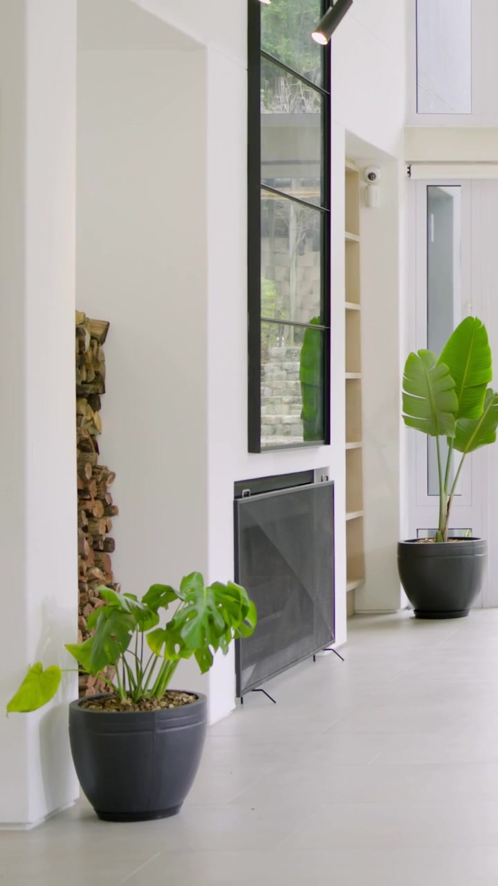 Video verticale: Telecamera che panoramica rivelando un divano curvo con tavolini a incastro a casa, mostrando il giardino.