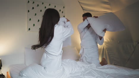 couple pillow fight in a glamping tent