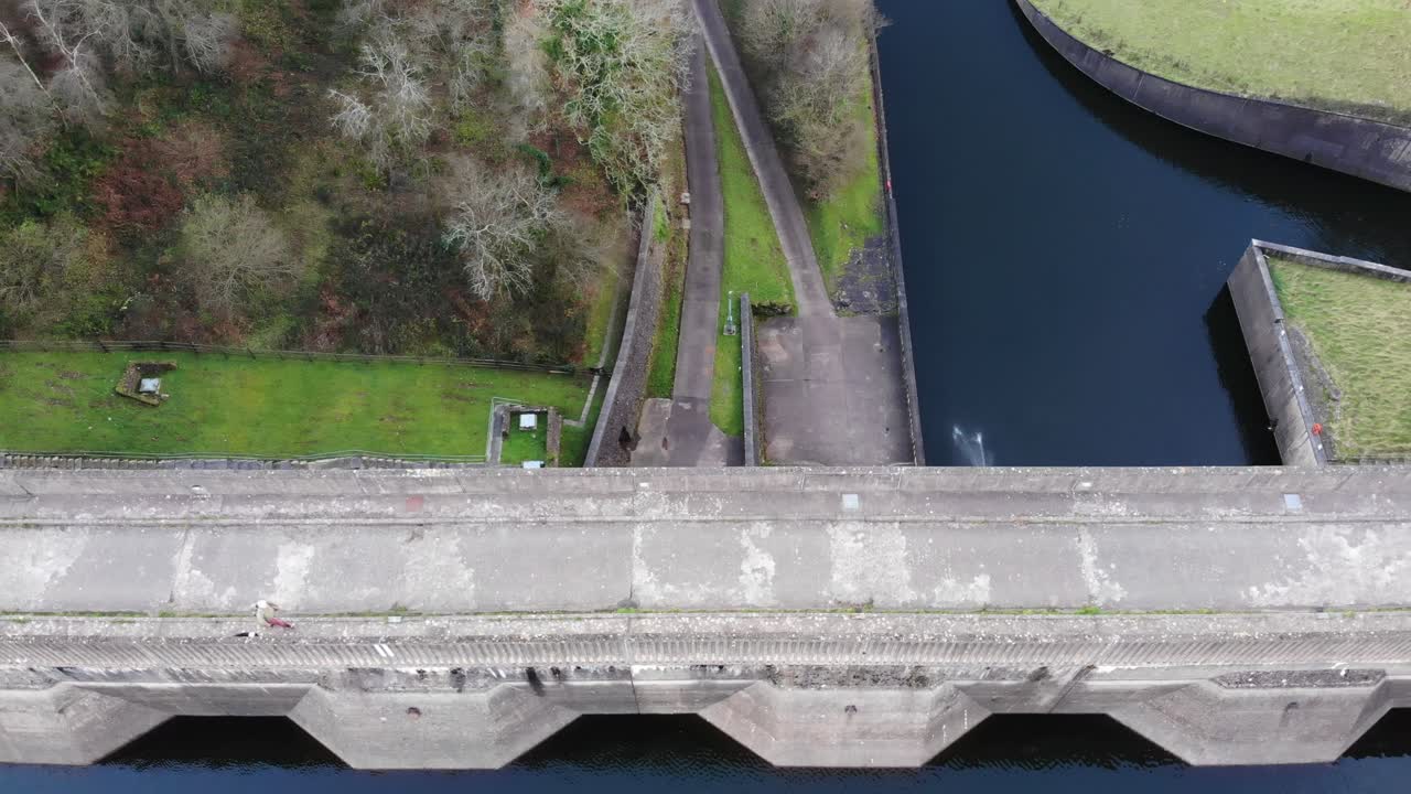 antena sobre el camino con gente caminando por la presa del lago wimbleball