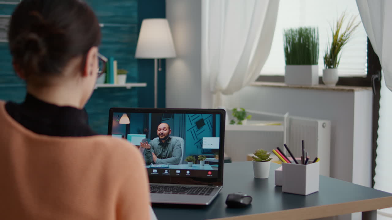 Female student attending online video call conference on laptop