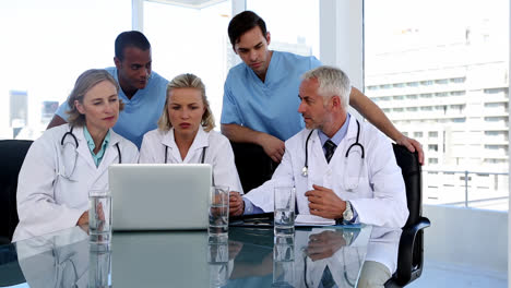 grupo de médicos usando una computadora portátil juntos