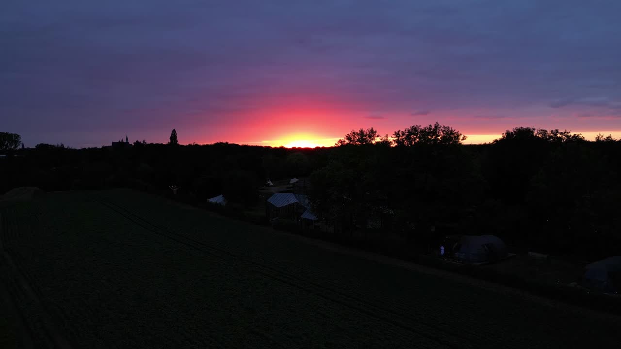 Dramatischer gold-orangefarbener Sonnenuntergangshimmel mit Landschaftssilhouette.