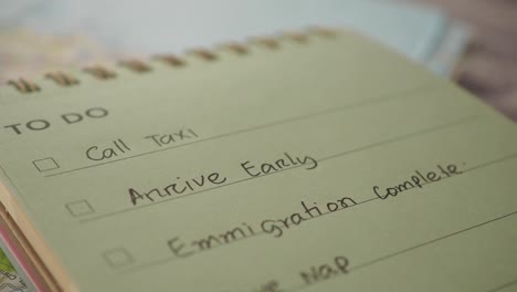 close-up of a 'to do' list in a notebook with travel-related items on a map
