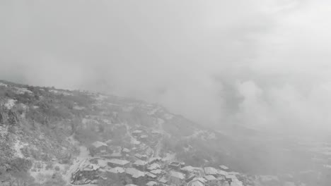 aerial footage over snowy mountain, traditional village in greece