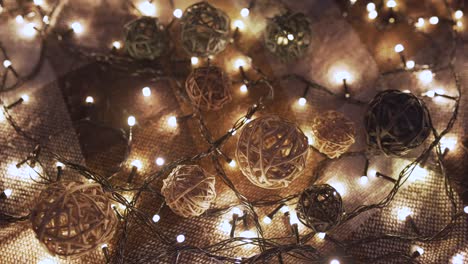 close-up christmas garland and handmade balls on a playd with golden lights. christmas concept. home decor